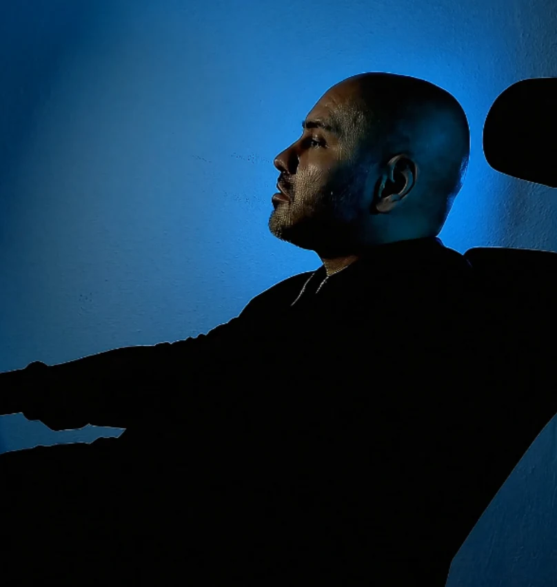 GRIMMGHOZT als dunkle Silhouette im Profil vor blau beleuchteter Wand